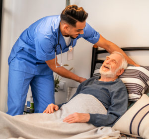 nurse helping senior in bed